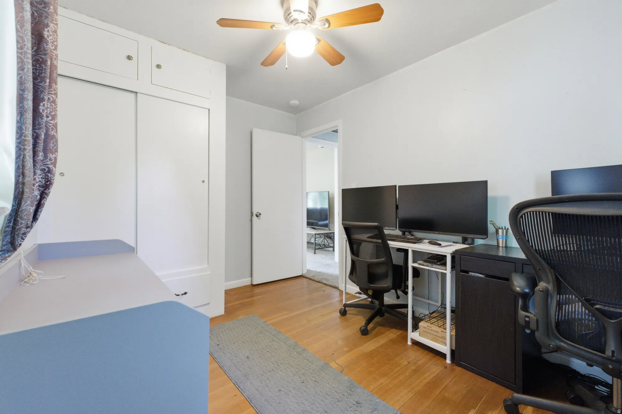 Additional view of the bedroom or office showing built-in closet storage and room for work-from-home setup.