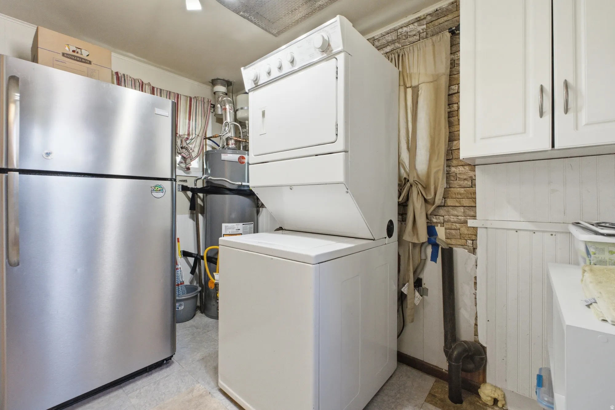 Additional utility room view showing laundry setup, water heater, storage space, and functional layout.