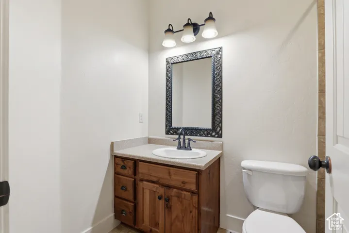 Bathroom vanity featuring wood cabinetry, an integrated sink, and a light-toned countertop