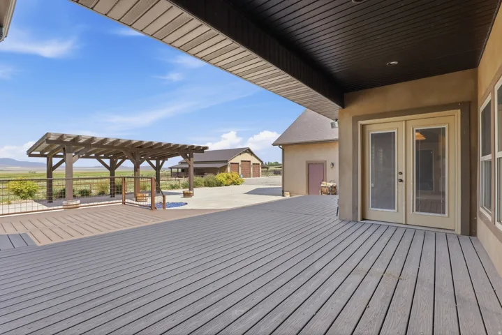Expansive outdoor deck featuring wood-finish composite decking and a covered pergola