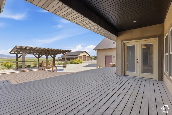 Expansive outdoor deck featuring wood-finish composite decking and a covered pergola