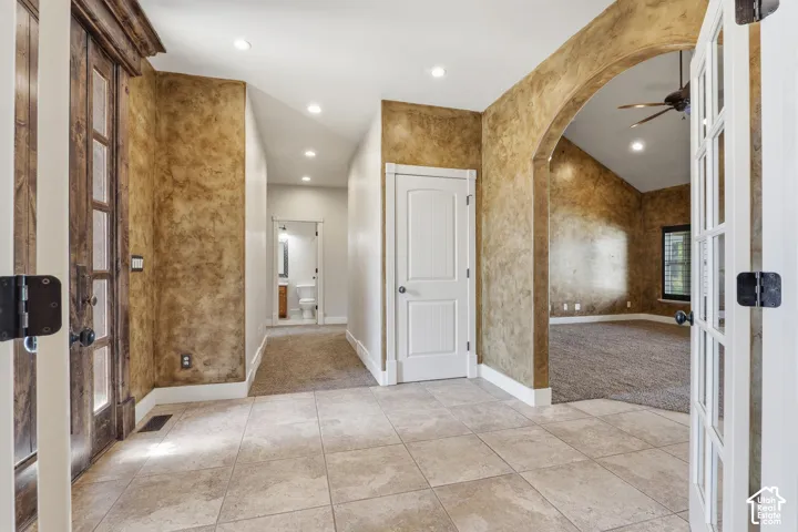 Spacious entryway with large format tile flooring, textured wall finishes, and recessed lighting