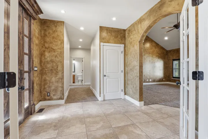Spacious entryway with large format tile flooring, textured wall finishes, and recessed lighting