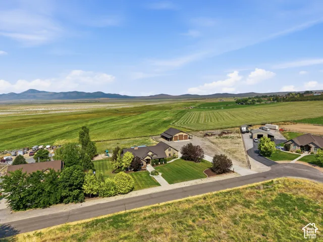 Expansive property featuring a main residence with manicured landscaping, a separate barn structure, additional outbuildings, and a paved driveway