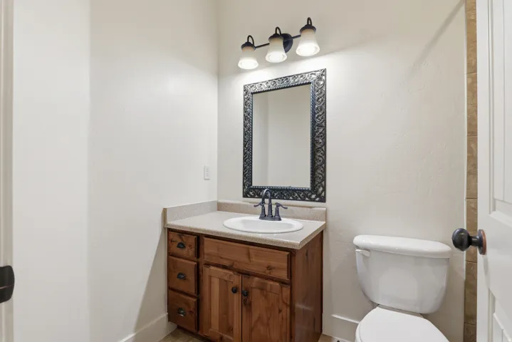 Bathroom vanity featuring wood cabinetry, an integrated sink, and a light-toned countertop