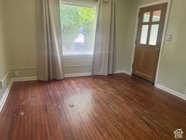 Wood flooring with baseboard molding and wall trim