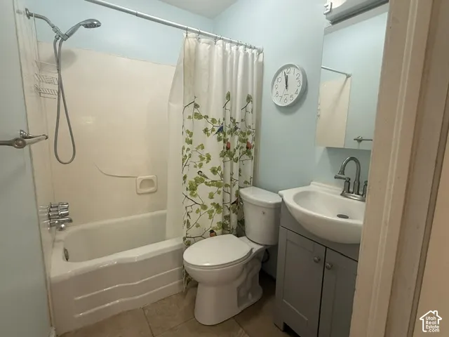 Full bathroom featuring a tub/shower combination with a single-handle faucet, a toilet, a vanity with a white basin and chrome faucet, and a wall-mounted mirror