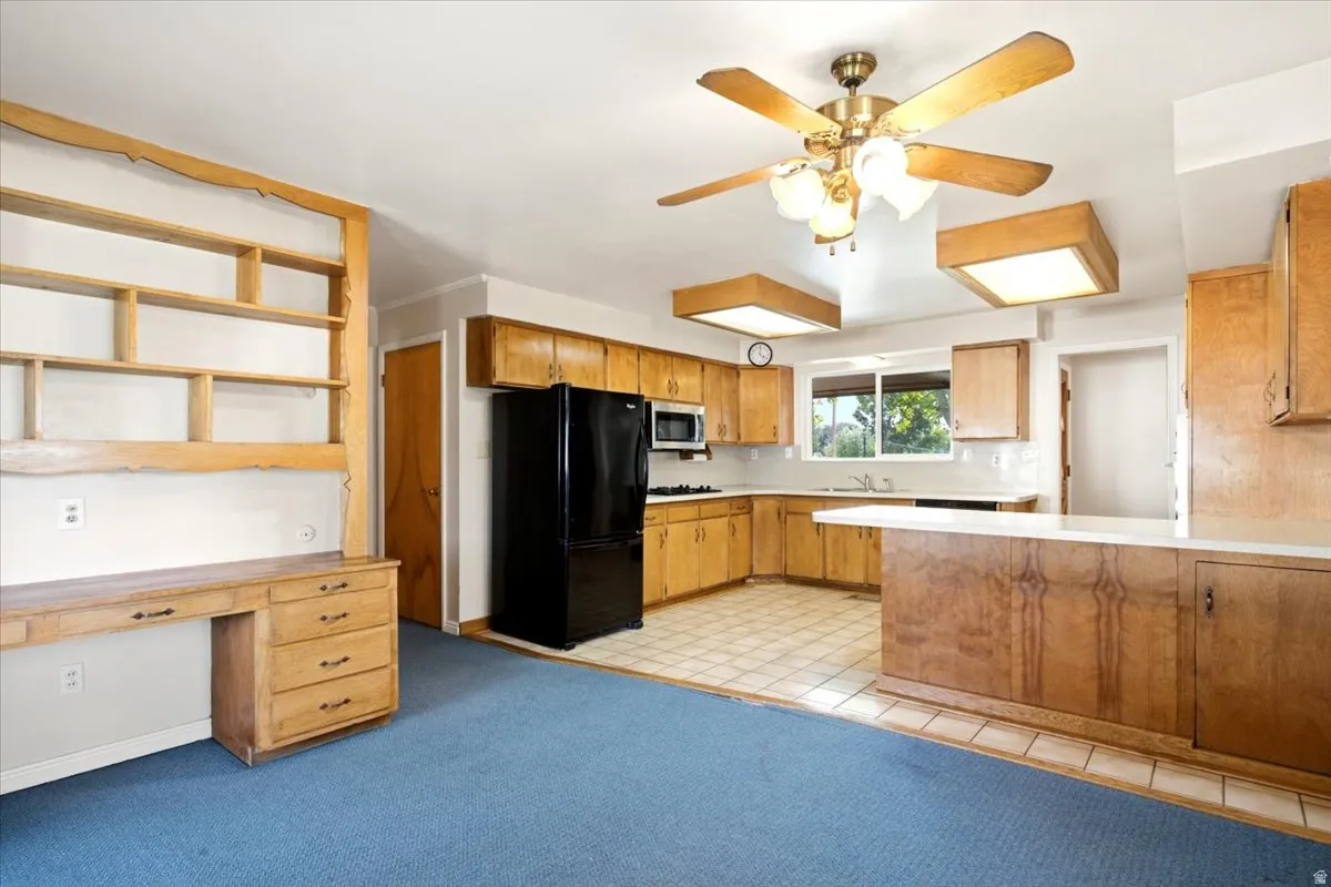 Kitchen featuring wood-finish cabinetry, tile flooring, and a breakfast bar