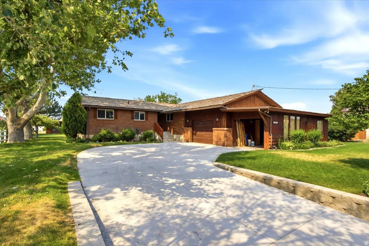 Brick and wood-sided residence featuring a multi-car concrete driveway