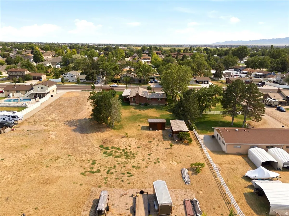 Expansive lot featuring a large, undeveloped parcel with partial fencing and established trees