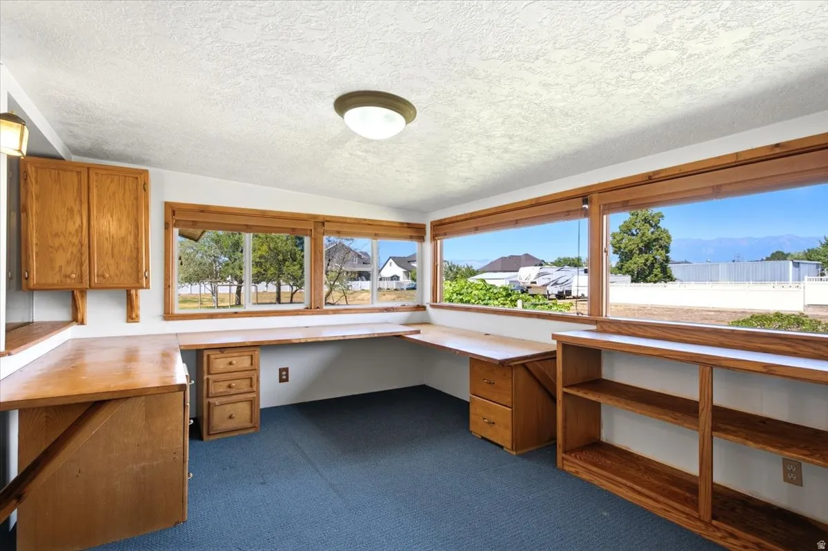 Room featuring built-in wood-finish cabinetry, integrated desk space, and expansive windows