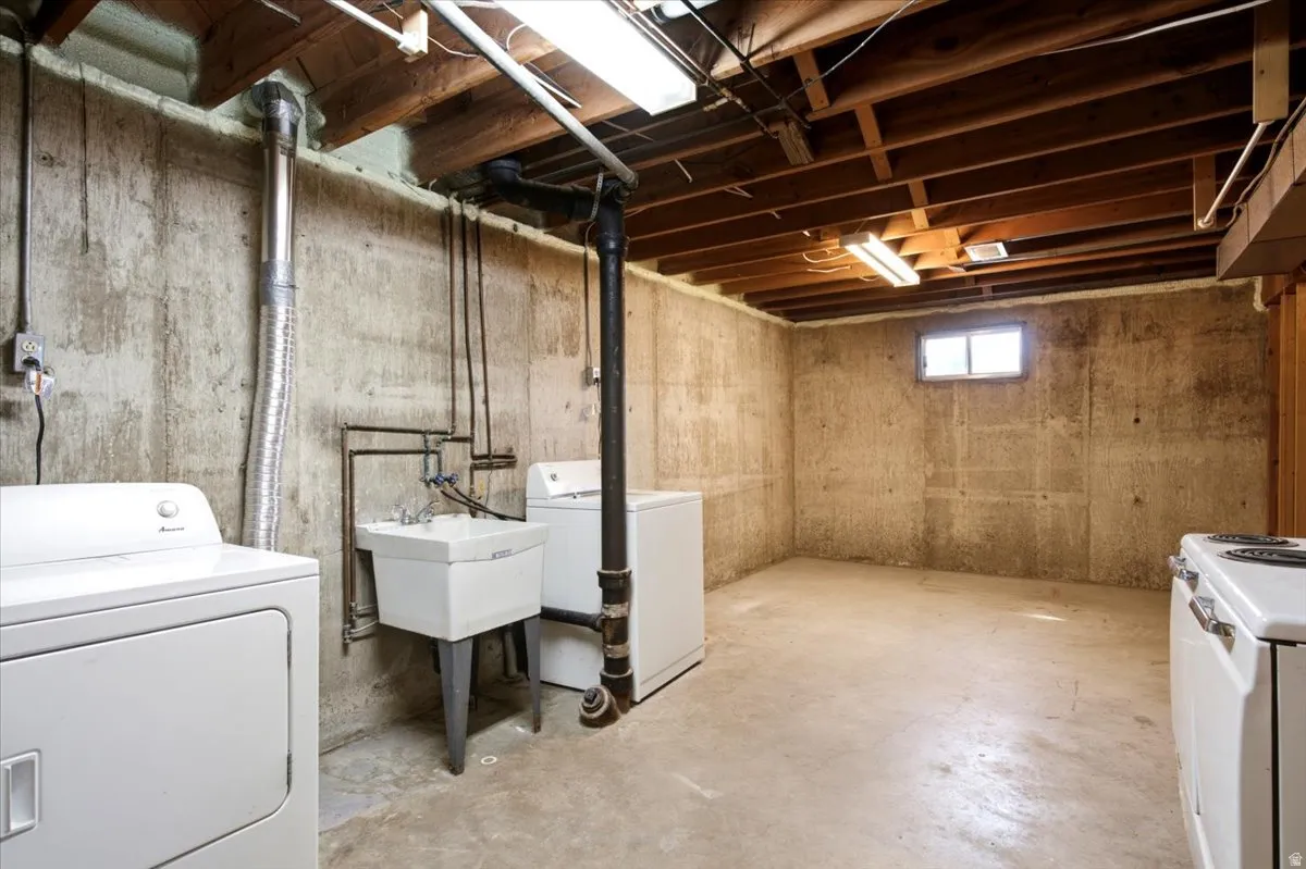 Lower-level utility area featuring exposed wood ceiling joists and concrete walls