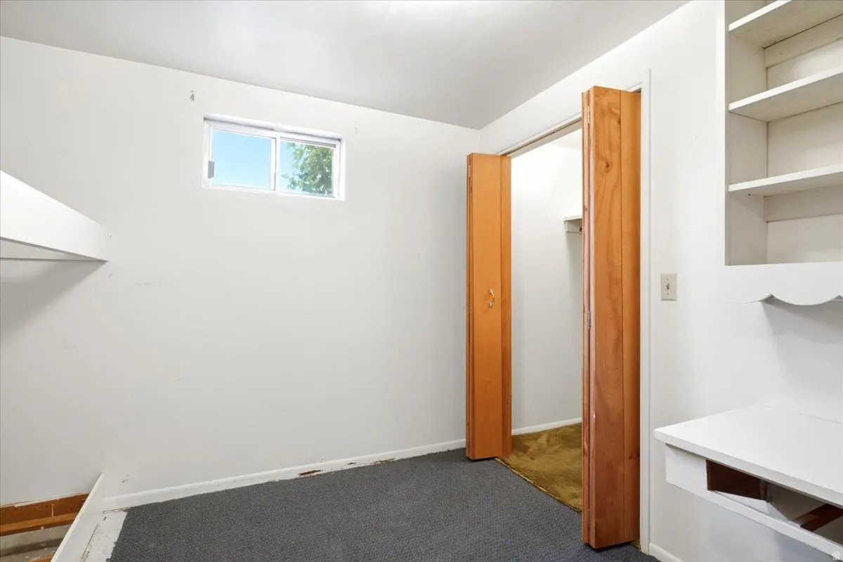 Compact room featuring dark grey carpeting and white painted walls