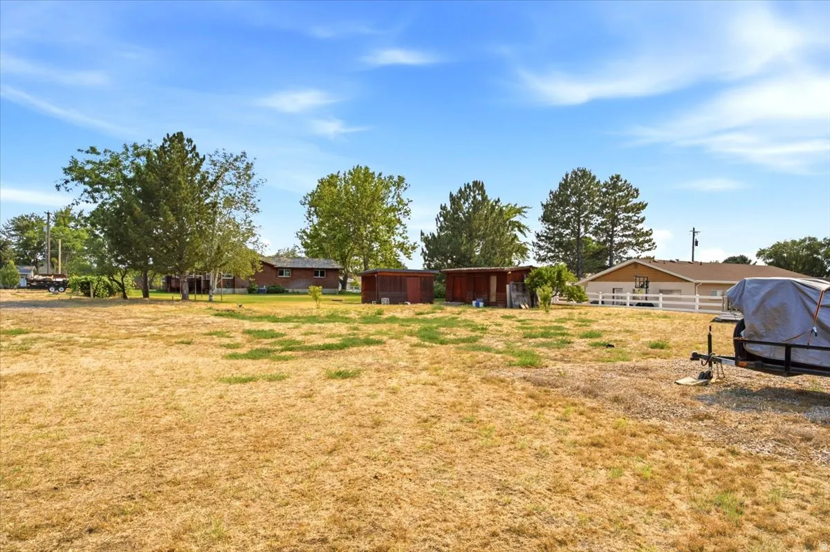 Expansive undeveloped land with mature trees and visible perimeter fencing
