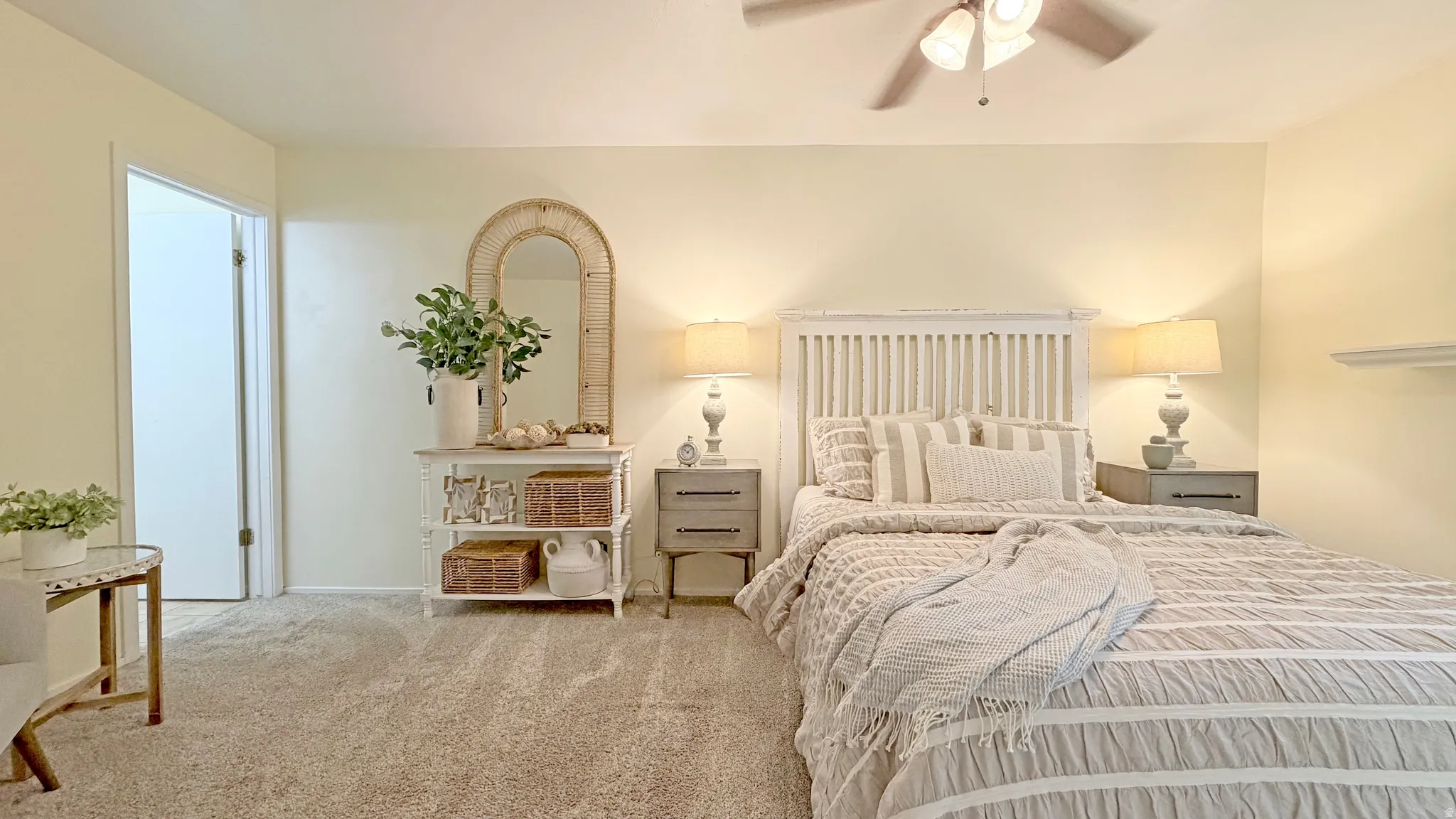 Carpeted bedroom featuring light-toned walls, and a ceiling fan with integrated lighting