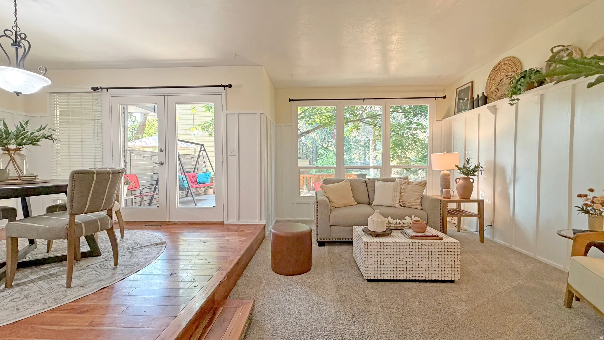 Interior featuring wood-finish flooring, light carpeting, board and batten wall detailing, and a wall of windows