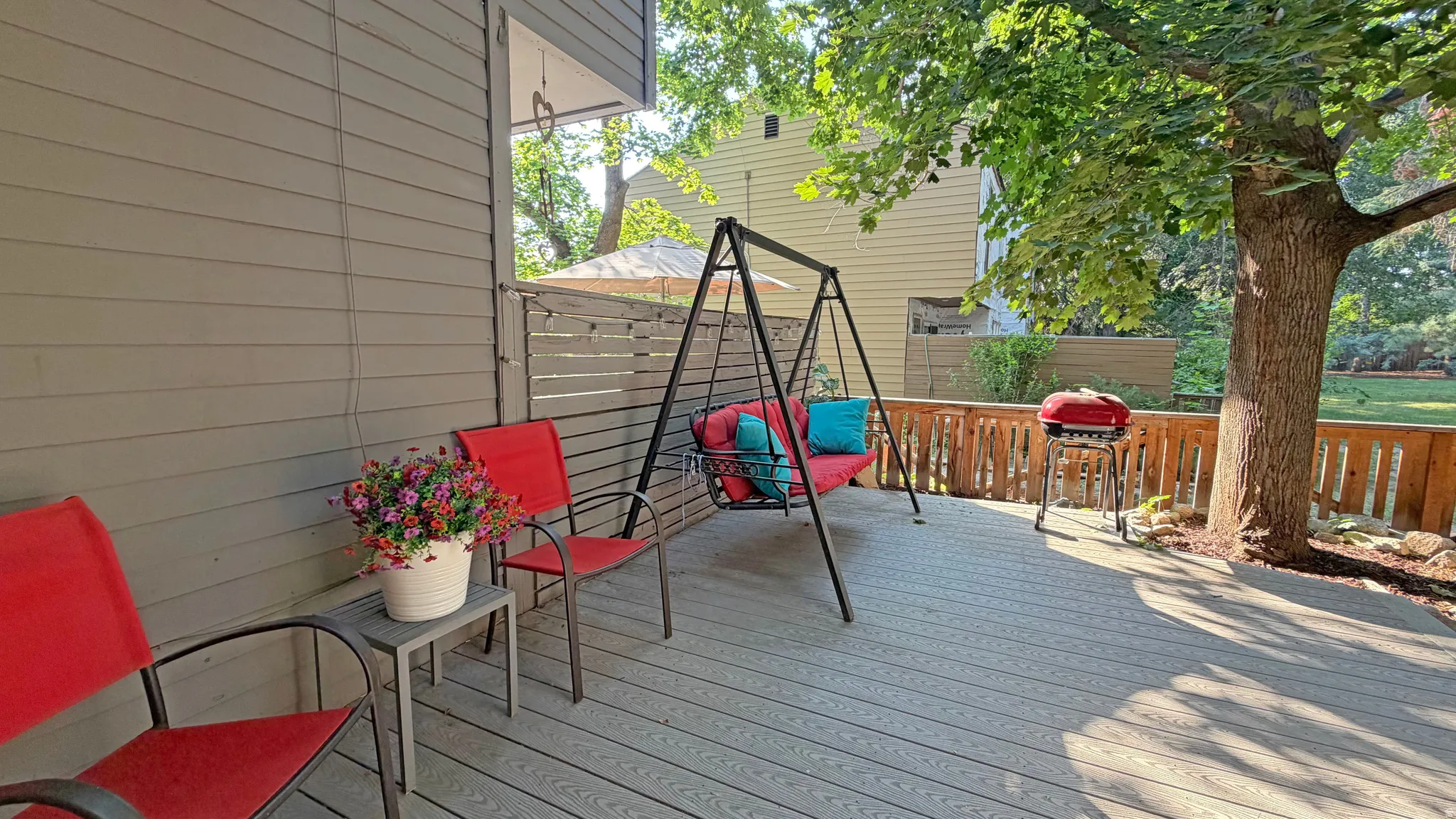 Spacious outdoor deck featuring composite decking, horizontal slatted privacy screen, and a natural wood railing