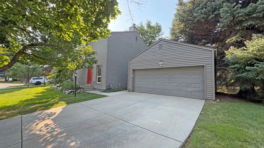 Contemporary gray siding exterior with a bright red front door.