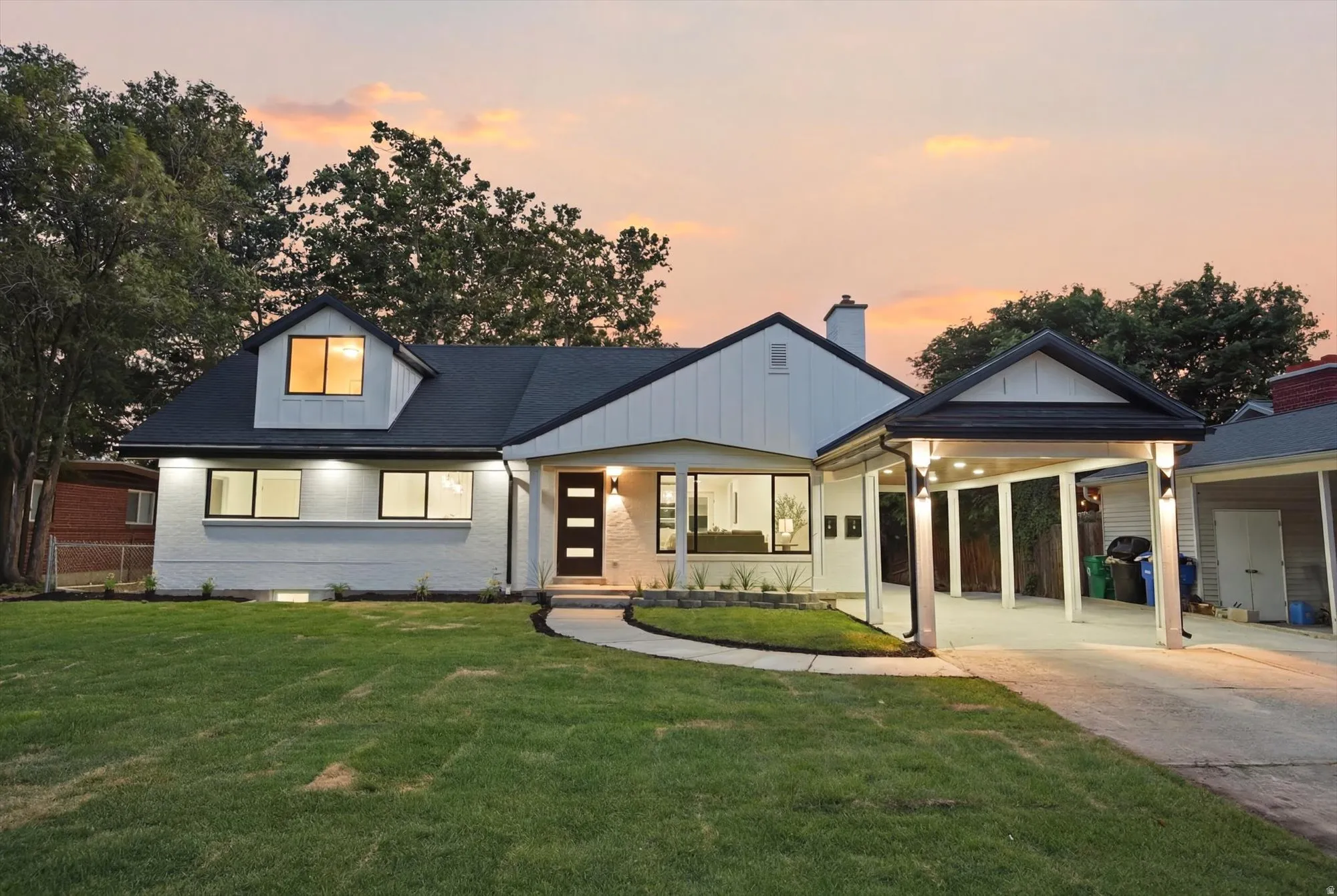 Modern white exterior with dark trim and black shingle roof
