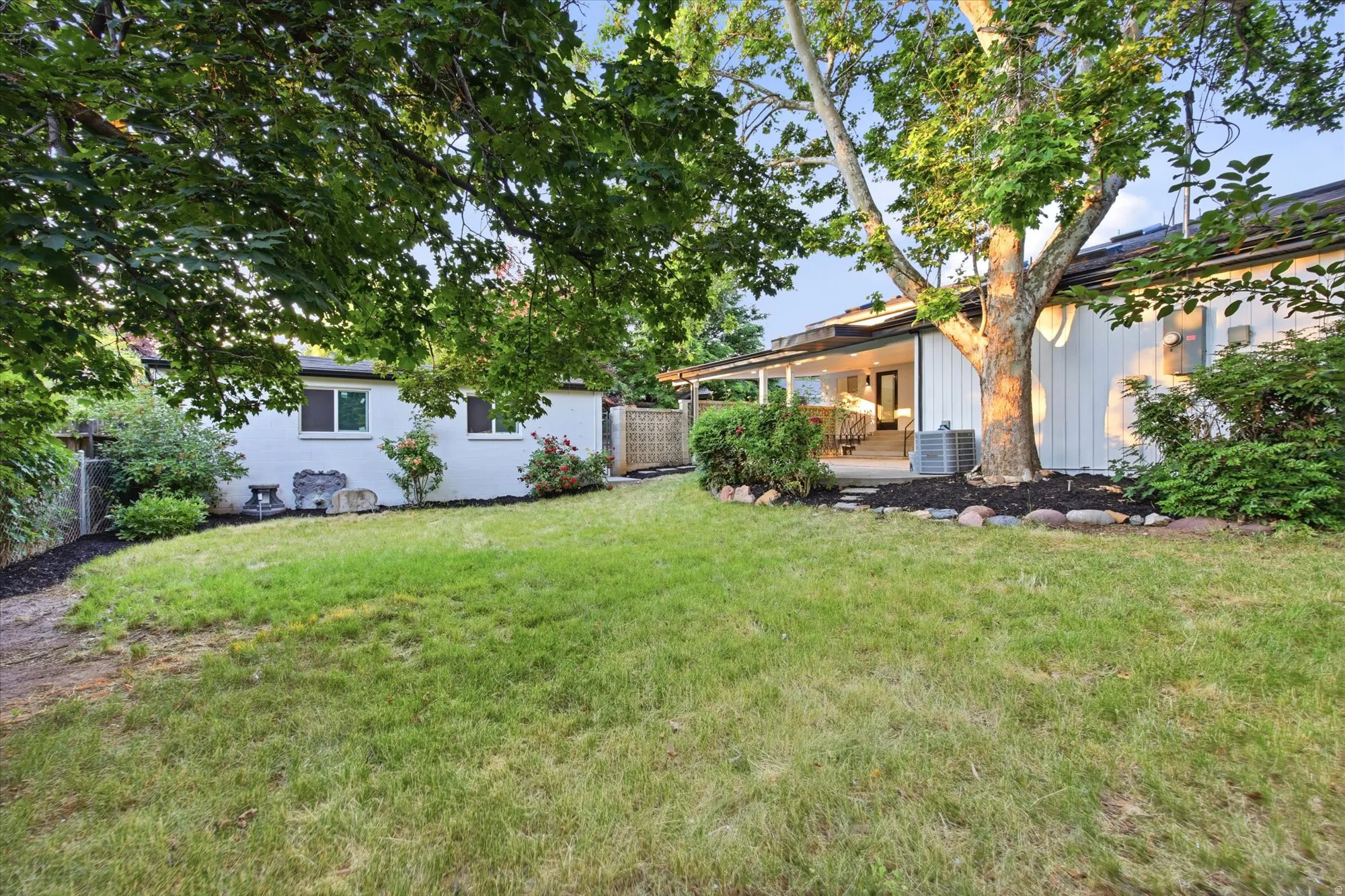 Expansive green lawn area featuring mature trees and established landscaping