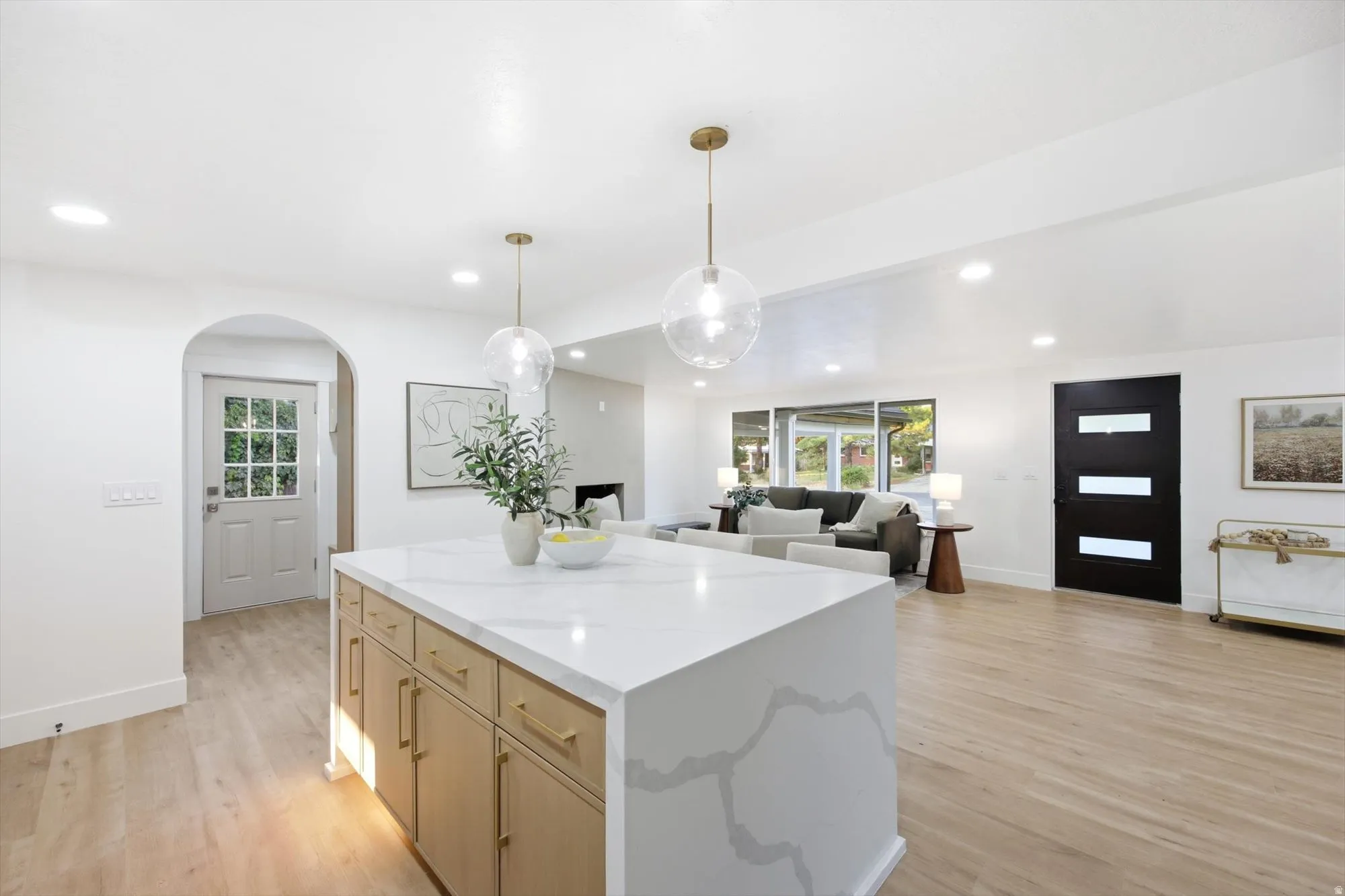 Kitchen island featuring a waterfall countertop and wood-finish cabinetry