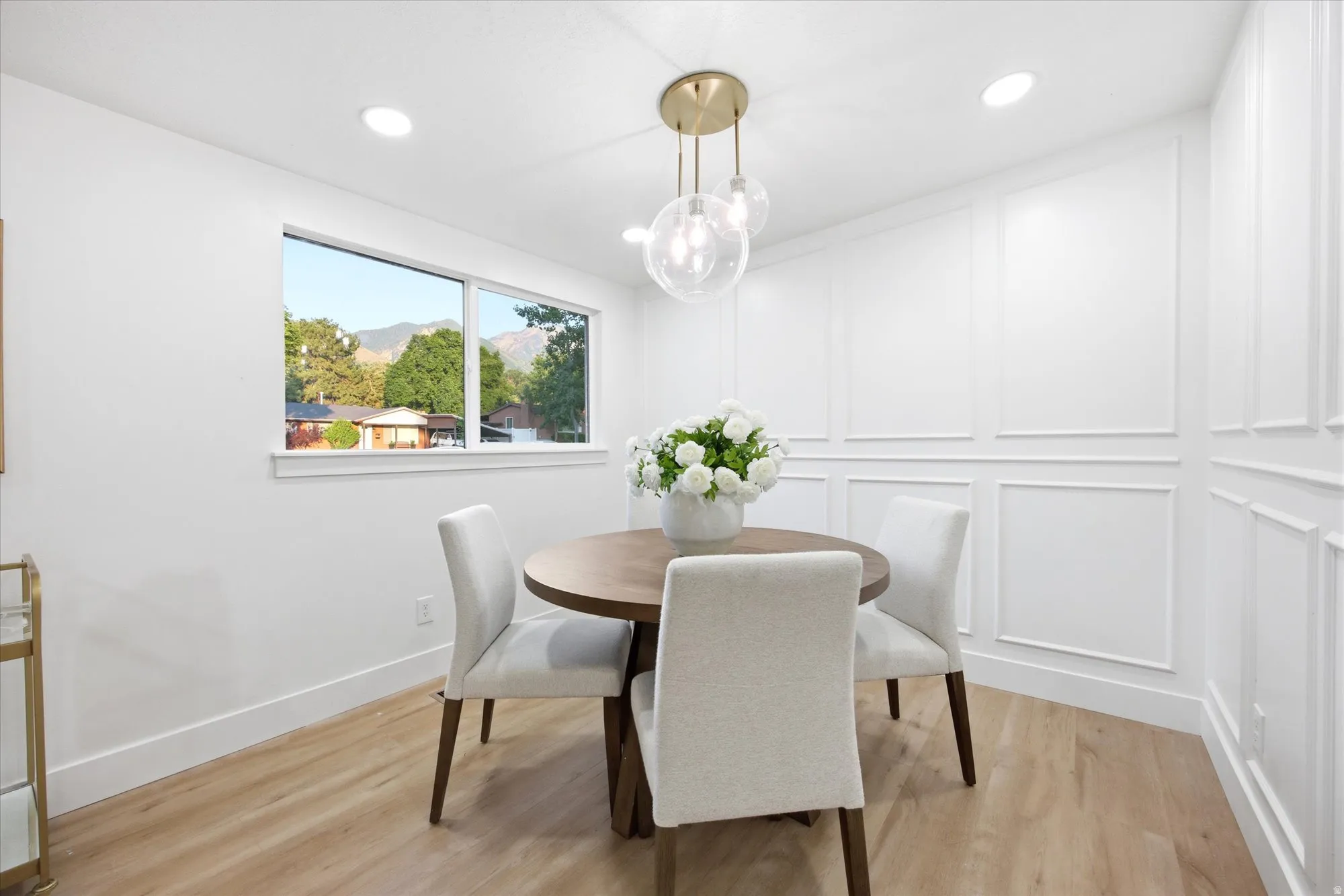 Dining area featuring wood-finish flooring, recessed ceiling lighting, and a contemporary chandelier