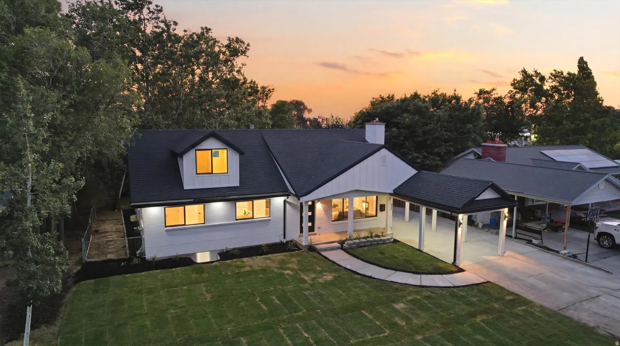 Modern single-story residence with a dormer, featuring a freshly installed dark shingle roof and white siding