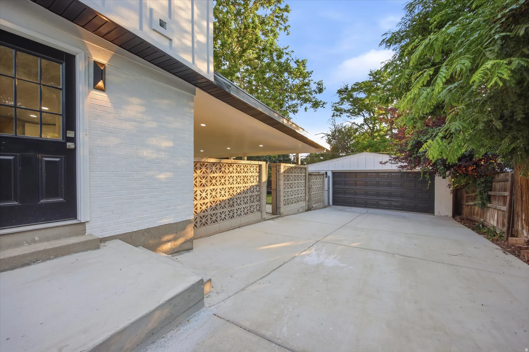 Carport with recessed lighting and a concrete driveway leading to a two-car garage