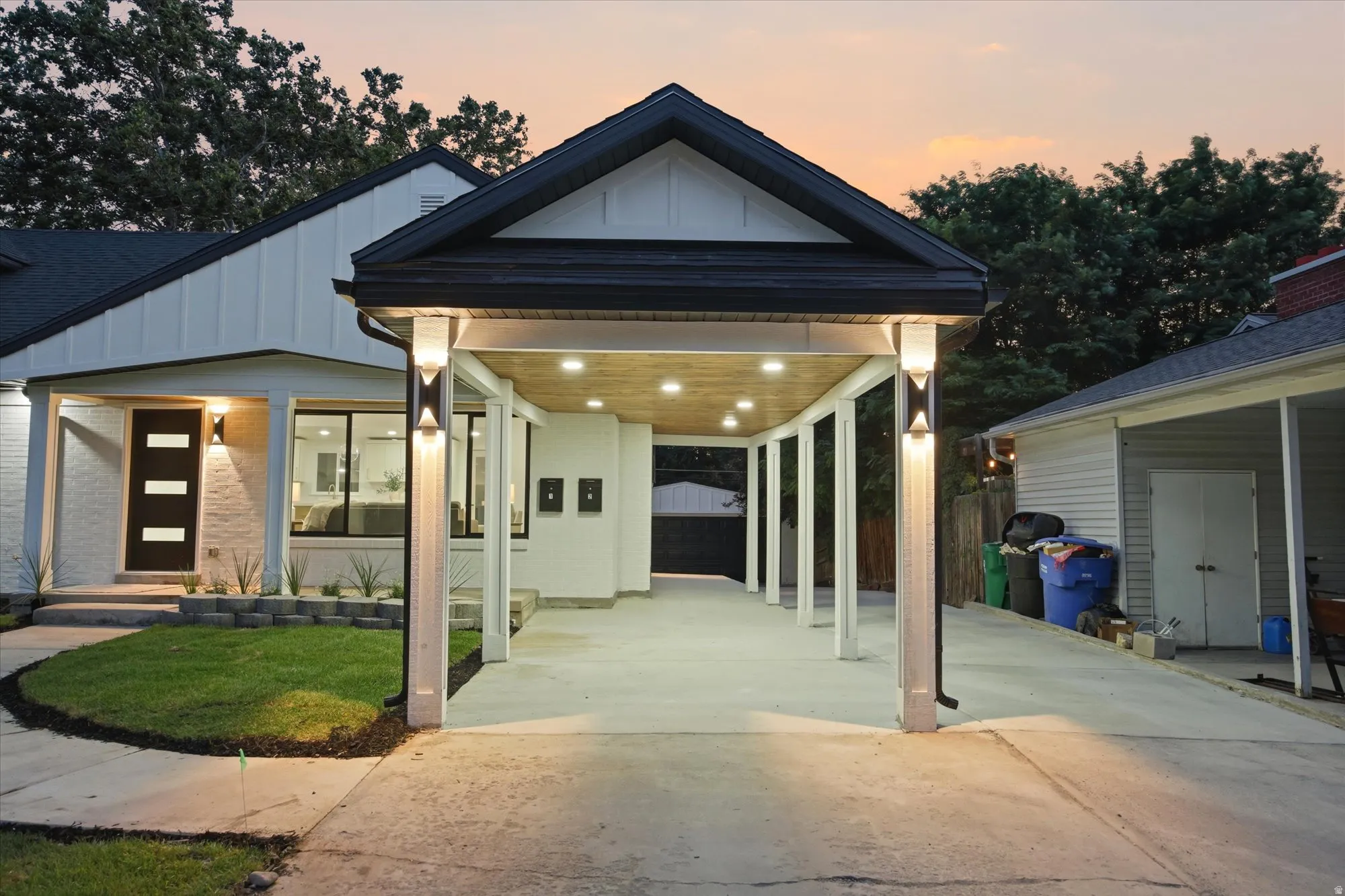Covered carport featuring recessed lighting and exterior sconces