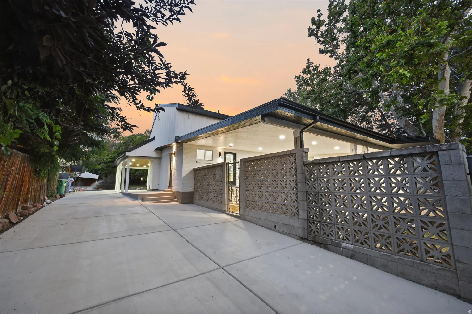 Expansive concrete driveway leading to a contemporary residence