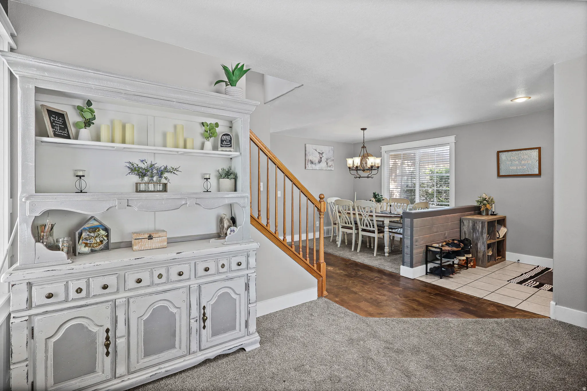 Dedicated dining area featuring wood-finish flooring, a contemporary chandelier, and ample natural light from a large window