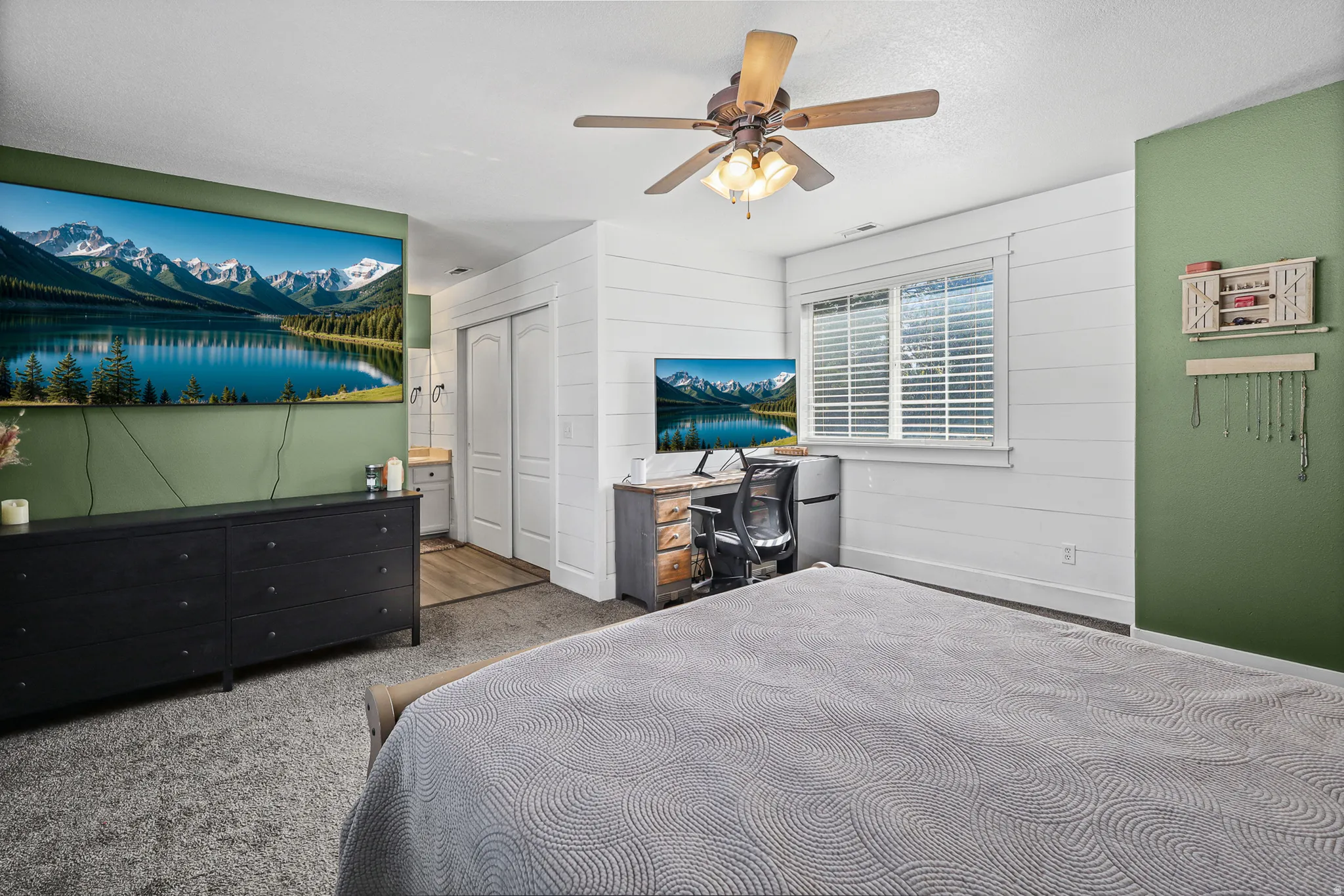 Spacious room featuring wood-finish flooring, a ceiling fan, and window blinds