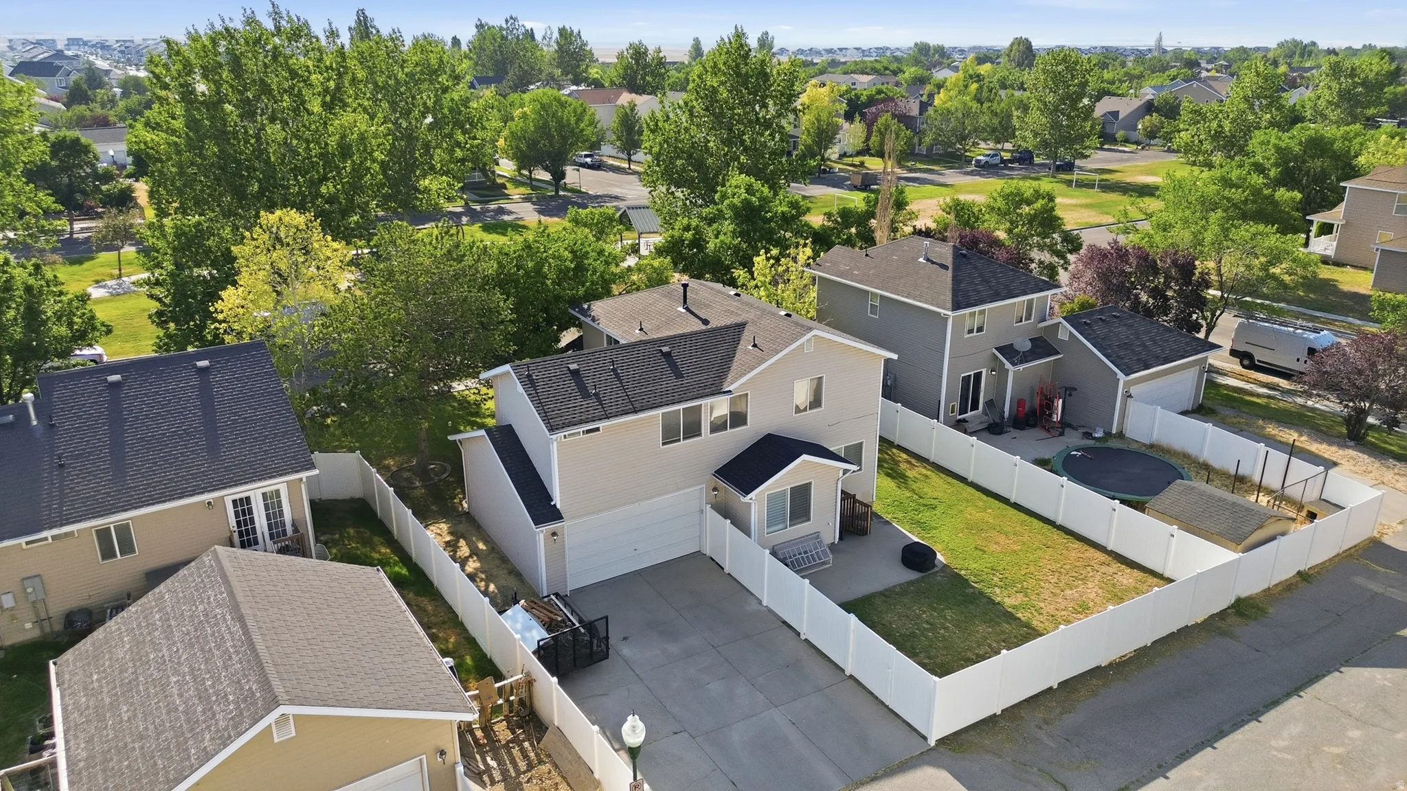 Two-story property with an attached two-car garage, a private backyard, and a white vinyl privacy fence