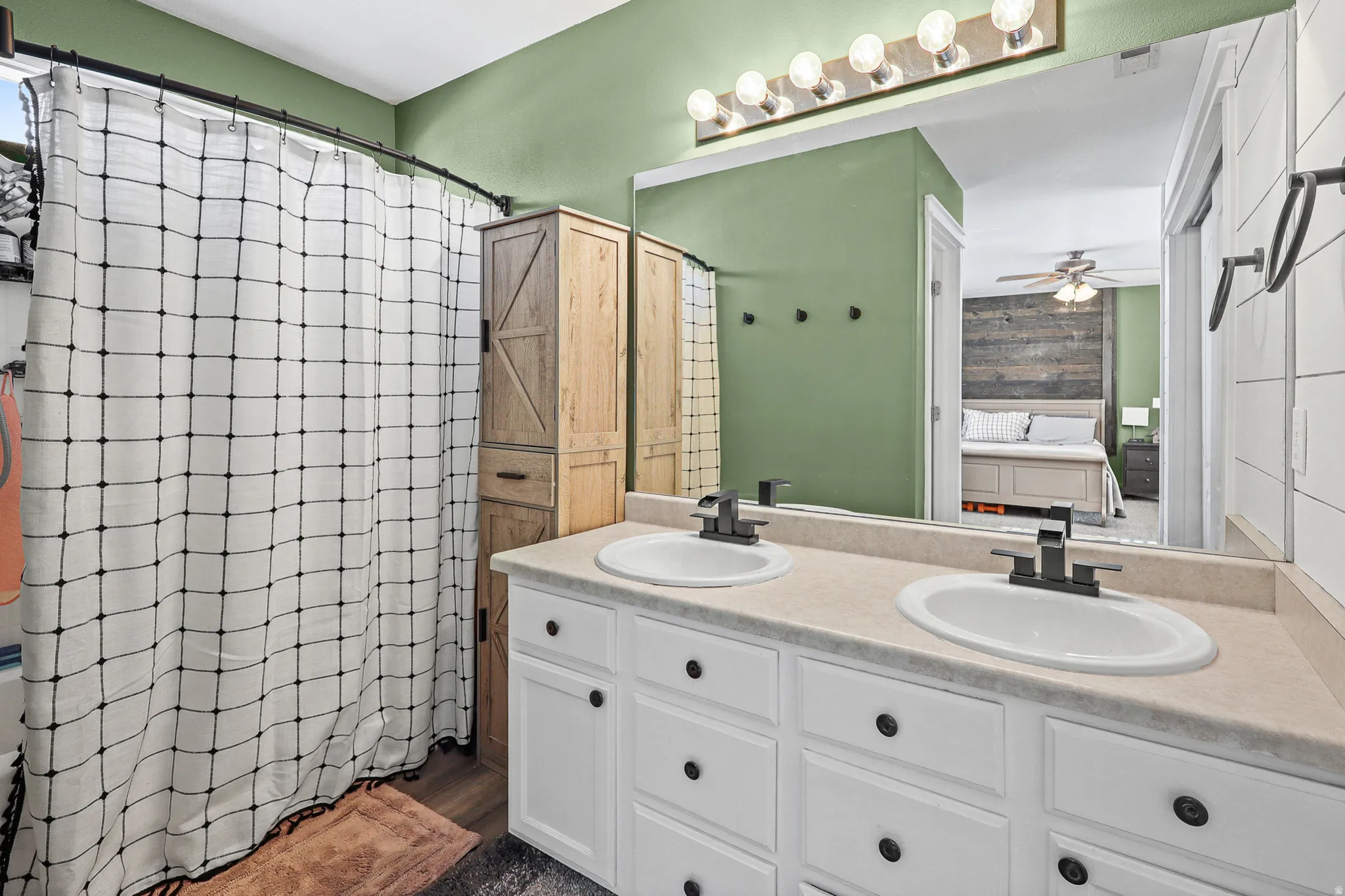 Dual vanity with white cabinetry, matte black hardware, and light-toned countertops