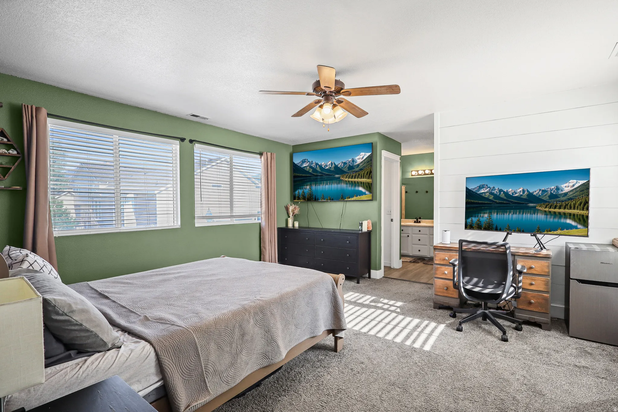 Spacious room featuring multiple windows, a ceiling fan with integrated lighting, and carpet flooring