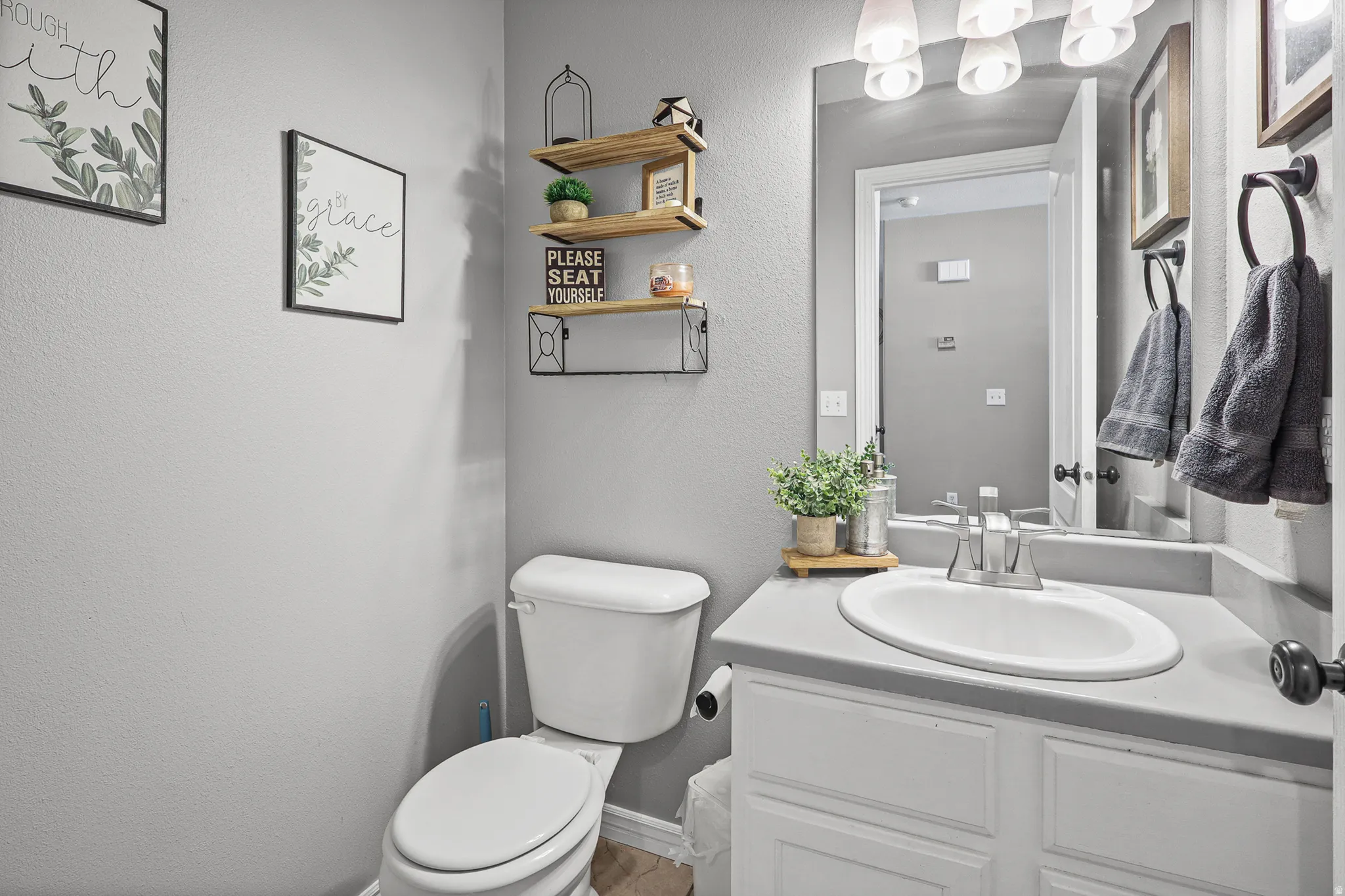 Bathroom vanity with an integrated white sink, gray countertop, and white cabinetry
