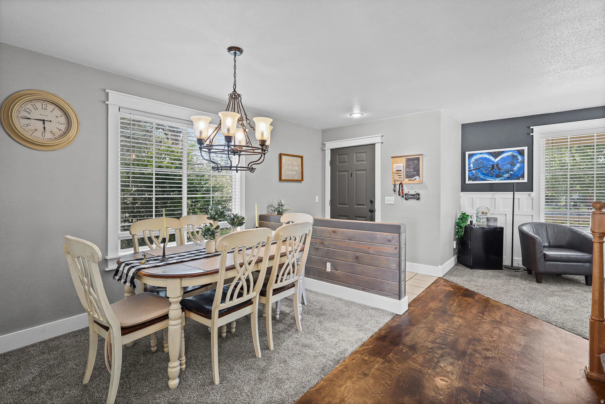 Dining area featuring a decorative chandelier, white trim window with blinds, and light gray wall paint