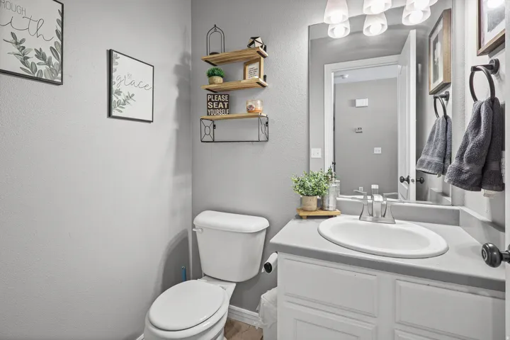 Bathroom vanity with an integrated white sink, gray countertop, and white cabinetry