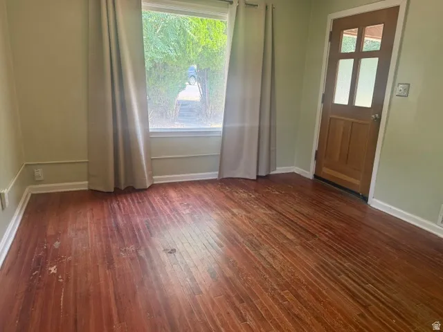 Wood-finish flooring with baseboard molding and wall trim