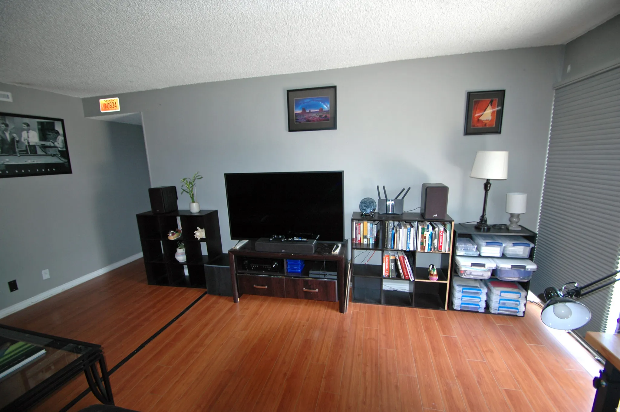 Expansive room featuring wood-finish flooring, light grey walls, and a textured white ceiling