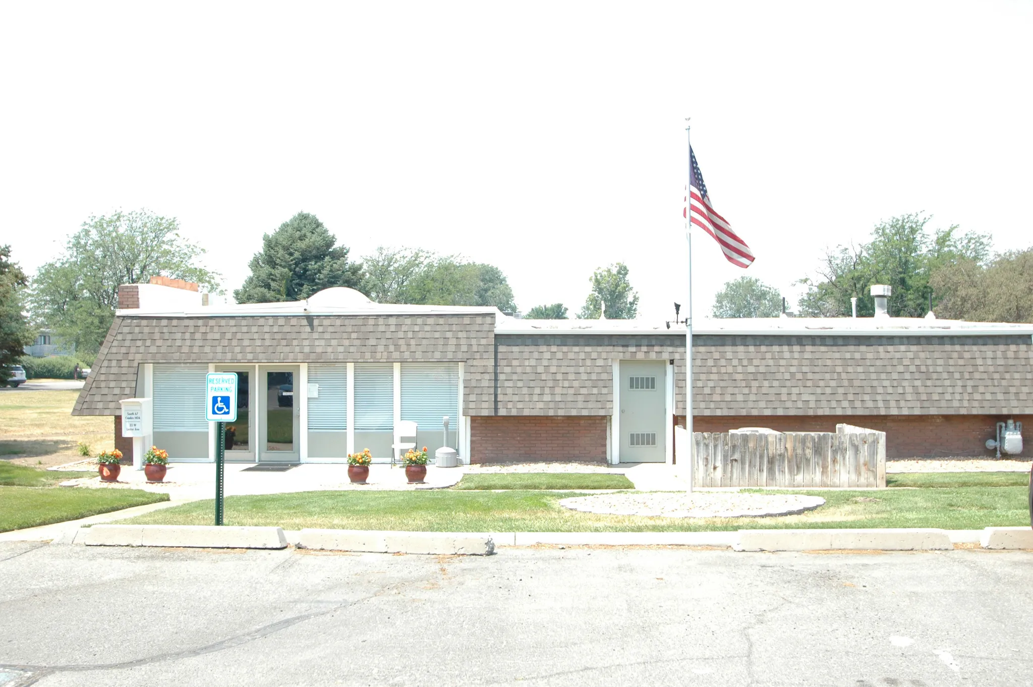 Commercial building with a shingled roof and brick base