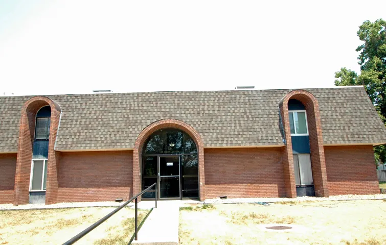 Brick exterior featuring a gabled roof and arched entryways
