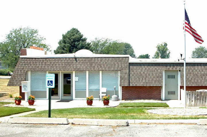 Commercial building featuring a shingled roof, brick facade, and a prominent entrance with glass doors