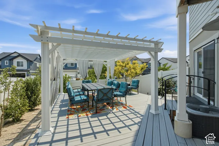 Large outdoor deck with a white pergola, offering partial shade