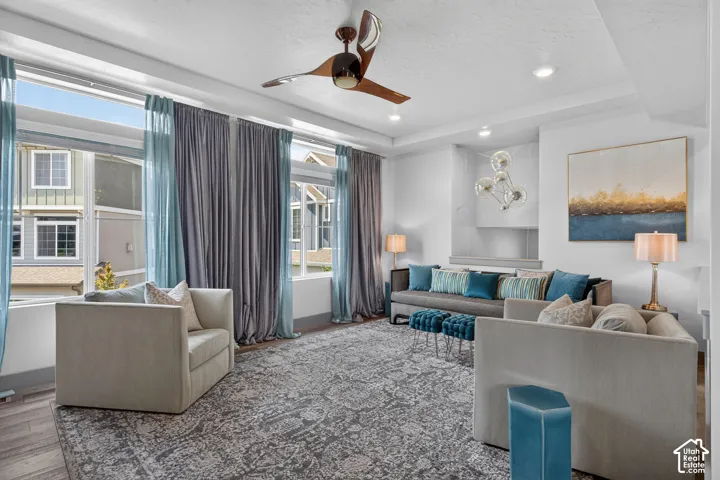 Large open windows with tons of natural lighting with recessed lighting, and a modern ceiling fan