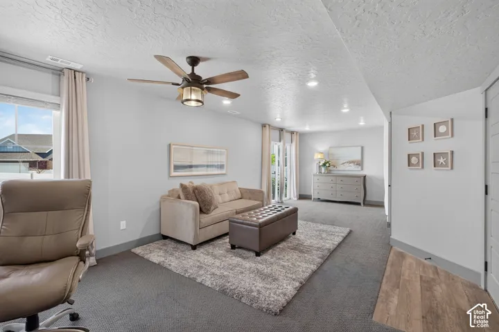 Recessed lighting, wood-finish ceiling fan, and carpeted flooring