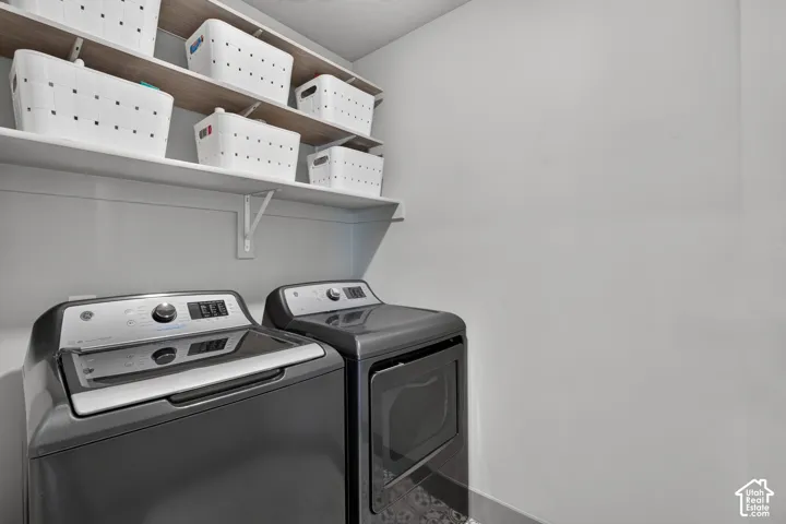Laundry area with built-in shelving and appliances