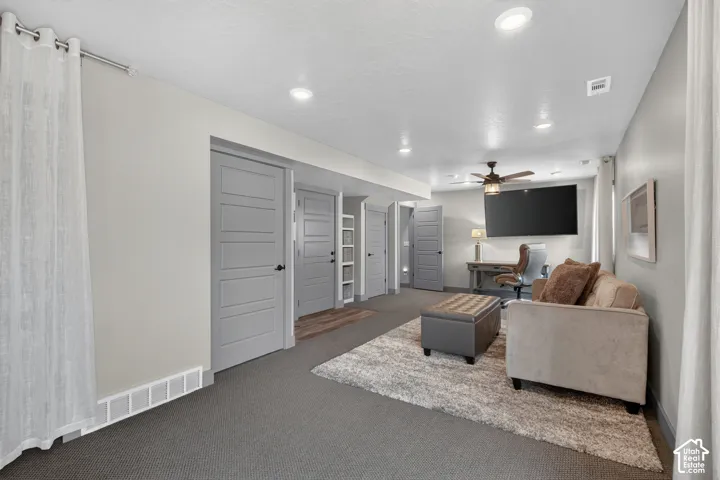 Recessed lighting, LVP flooring, ceiling fan, grey panel doors, and wall-mounted television