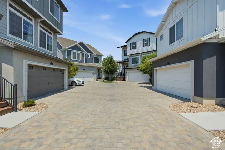 Paved driveway with stone pavers, leading to attached garages