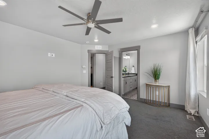 Recessed lighting, ceiling fan, grey carpet, window with white trim, and a doorway with dark trim